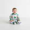 A smiling baby wearing a Twinkles Avengers print long-sleeve pajama set with green trim on a white background