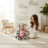 Twinkles baby wearing a cozy cow-patterned polar fleece hooded romper with pink belly detail in a nursery