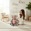 Twinkles baby wearing a cozy cow-patterned polar fleece hooded romper with pink belly detail in a nursery