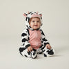 Twinkles baby wearing a cozy black and white cow-patterned polar fleece jumpsuit with a hooded animal face