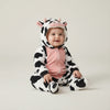 Twinkles baby wearing a cozy black and white cow-patterned polar fleece jumpsuit with a hooded animal face