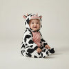 Twinkles baby wearing a cozy cow-print polar fleece hooded bunting with pink accents and enclosed feet.