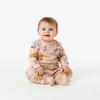 Twinkles baby wearing a soft pink long-sleeve pajama set with cute hi bear and animal print patterns