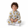 A young boy wearing a grey Twinkles Simba print fleece pajama set while sitting on a white background.
