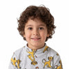 A smiling boy with curly hair wearing a Twinkles Simba print grey fleece winter pajama top